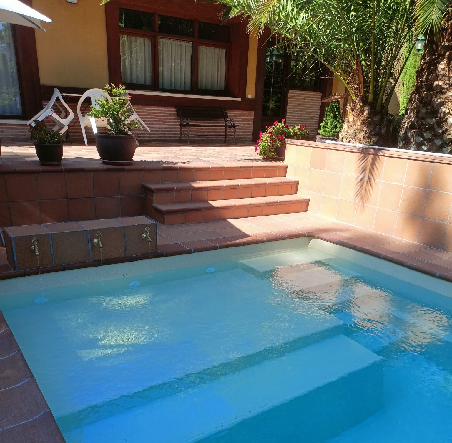 Instalación de piscina de obra con azulejos cerámicos modernos y coronación de piedra