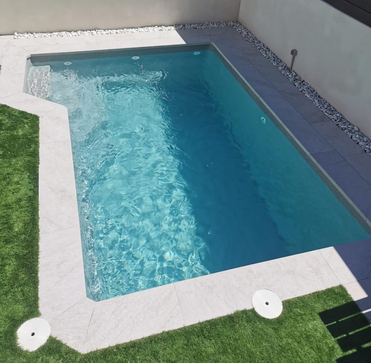 Diseño y ejecución de piscina de obra a medida con escalera interior y zona de relax